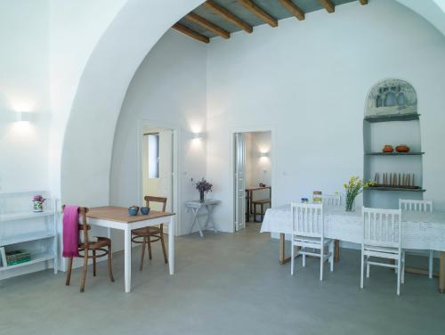 a dining room with white tables and chairs at Tutti Blu Tinos Living Space in Mési