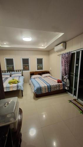 a bedroom with two beds and a sink in it at บ้านแสงเพ็ญ by แช่มช้อย in Ban Khao Ya Nua