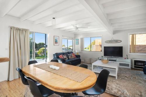 a living room with a wooden table and chairs at MeNo's at Bawley in Bawley Point