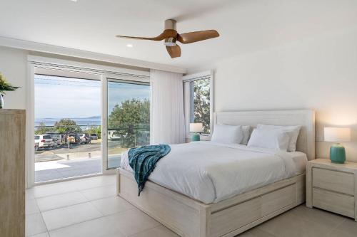 a bedroom with a bed and a large window at Thalassa Views Ulladulla in Ulladulla
