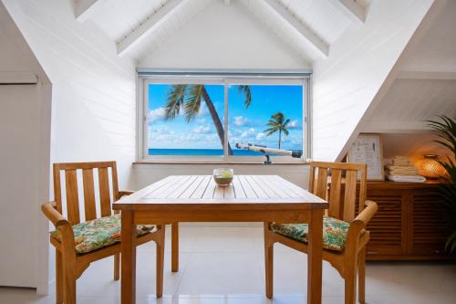 a dining room with a table and two chairs and a window at Deja Blue - Comfortable Beachfront condo in Marigot