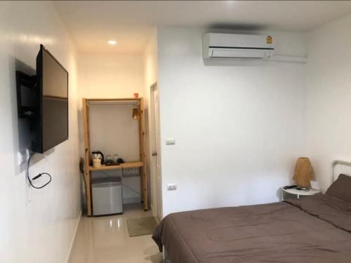 a bedroom with a bed and a flat screen tv at Homestay Laksi in Lak Si