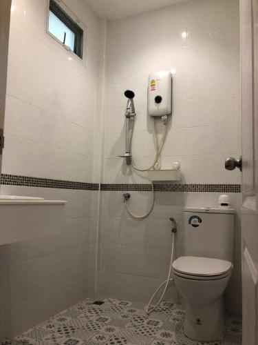a bathroom with a toilet and a phone on the wall at Homestay Laksi in Lak Si