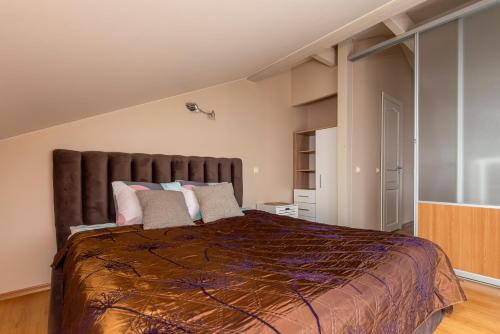 a bedroom with a large bed with pillows at Vila Romantika in Palanga