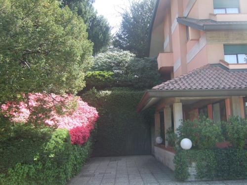 a building with bushes and flowers next to a building at Hotel Canturio in Cantù