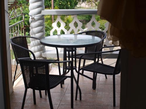 a table and chairs sitting on a porch at Memories Cottage and Apartments in Buccoo