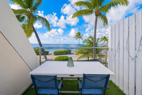 a table and two chairs on a balcony with a view of the ocean at Deja Blue - Comfortable Beachfront condo in Marigot