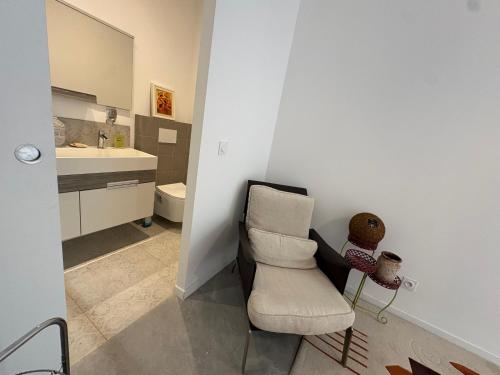 a bathroom with a chair and a sink at Studio en maison historique in Golfe-Juan