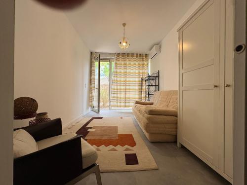 a living room with a couch and a window at Studio en maison historique in Golfe-Juan