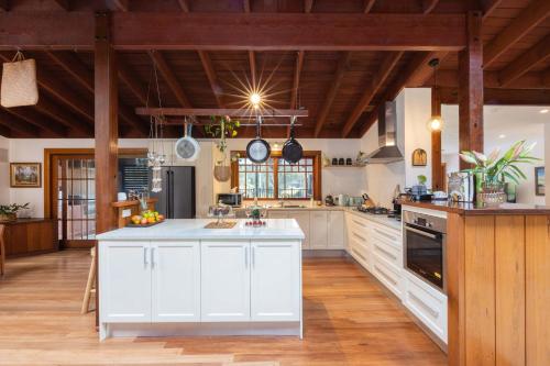a kitchen with white cabinets and a white counter top at Banyula in Bawley in Bawley Point