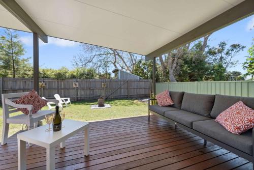 a patio with a couch and a table at Barker Retreat in Burrill Lake