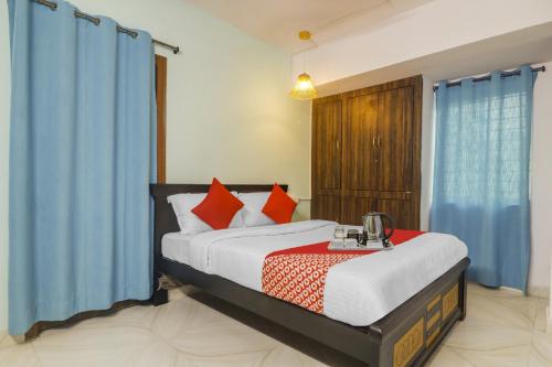 a bedroom with a large bed with blue curtains at Hotel O RR in Kondapur
