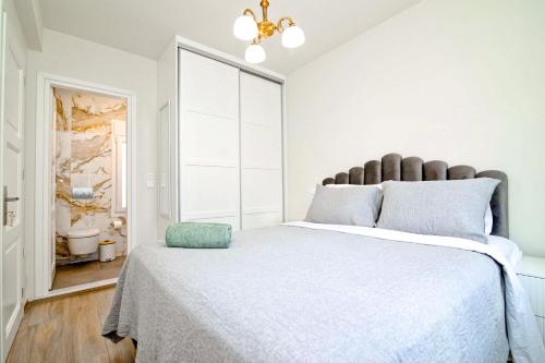 a white bedroom with a large bed and a window at Villa St George in Kalymnos