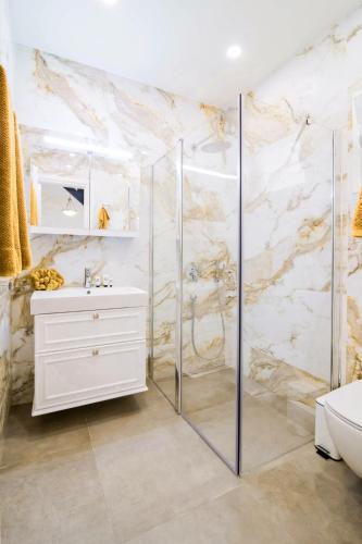 a bathroom with a shower and a white sink at Villa St George in Kalymnos