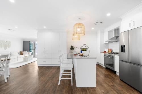 a kitchen with white cabinets and a white counter top at Sanctuary Splash Getaway in Sanctuary Point