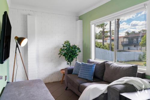 a living room with a couch and a large window at Kangaroo Sanctuary Studio in Sanctuary Point