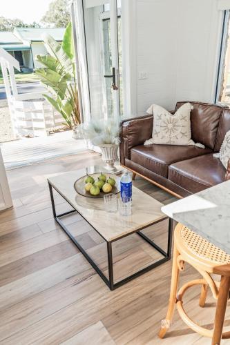 a living room with a couch and a coffee table at Chapel by the Bay in Erowal Bay