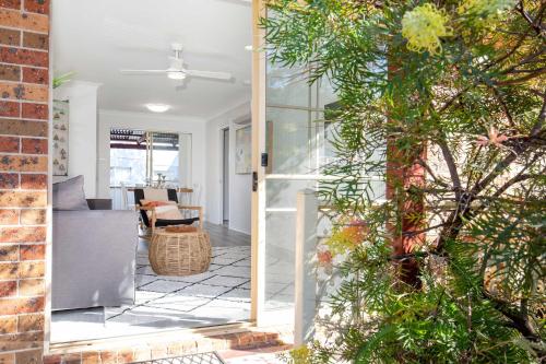 a view of a living room from the porch of a house at Aquamarine - modern & bright Huskisson townhouse in Huskisson