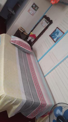 a bed in a room next to a table at Waikiki Guest House in Treasure Beach