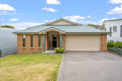 a brick house with a garage at Footprints at Hyams Beach - 4BR home w. games room in Hyams Beach