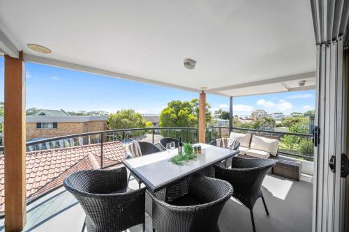 a patio with a table and chairs on a balcony at Karinya Jervis Bay - 4BR home & optional studio in Vincentia