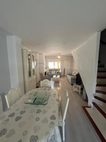 a white room with a table and a living room at Casa Flores in El Campello