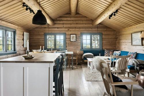 a kitchen and dining room with wooden walls and windows at Traditional Log Cabin At Vierli in Rauland