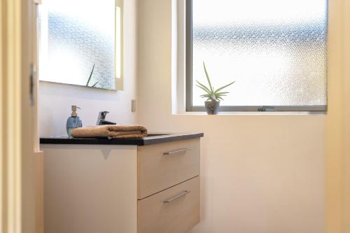a bathroom with a sink and a window at Hyggeligt værelse med lækkert badeværelse in Horsens