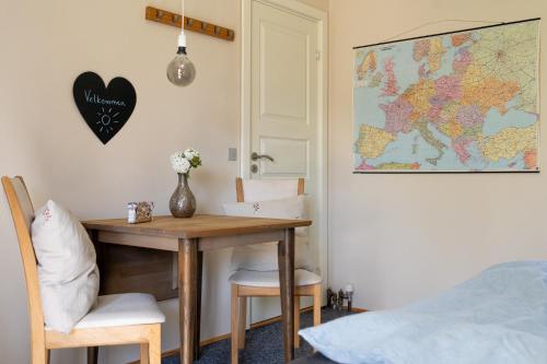 a room with a table and a map on the wall at Hyggeligt værelse med lækkert badeværelse in Horsens