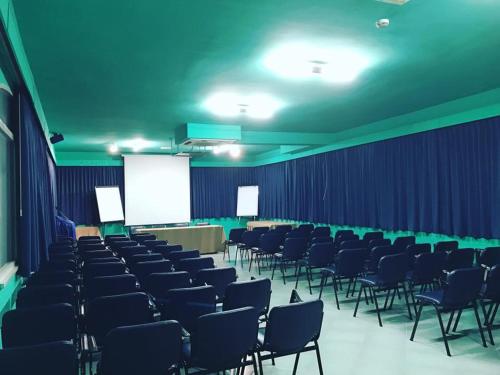 a conference room with chairs and a white screen at Aequa Hotel in Vico Equense