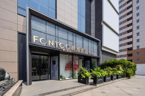 a store front of a building with plants at 枫渡酒店上海陆家嘴世纪大道地铁站店 in Shanghai