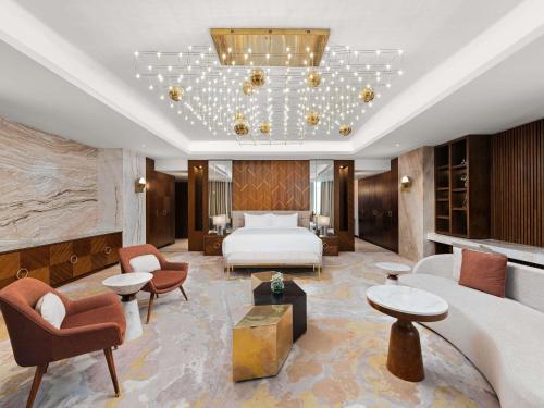 a hotel room with a bed and a bed and chairs at Movenpick Hotel Centaurus Islamabad in Islamabad