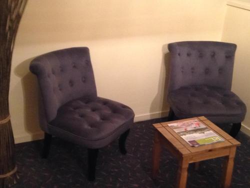 two chairs and a table in a room at hôtel QUICK Palace Tours Nord in Tours