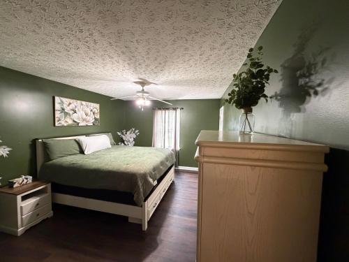 a bedroom with green walls and a bed with a plant at Marvielous Stay in Jacksonville