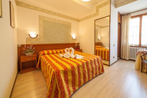 a hotel room with a bed with a towel on it at Hotel Ricordo Du Parc in Tabiano