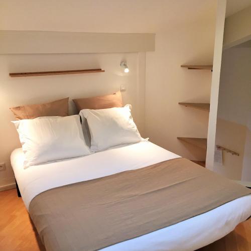 a bed with white sheets and pillows in a room at Résidence Thibaud in Toulouse