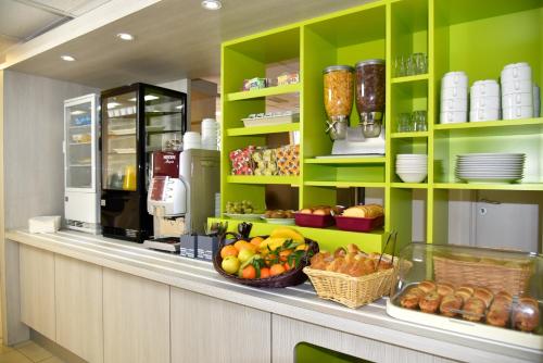 une cuisine avec des étagères vertes et des fruits sur un comptoir dans l'établissement Sweet and Smart Sarreguemines - Hambach, à Hambach