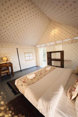 a bedroom with a large bed and a table at Rangmahal Pushkar by DIV HOSPITALITY in Pushkar