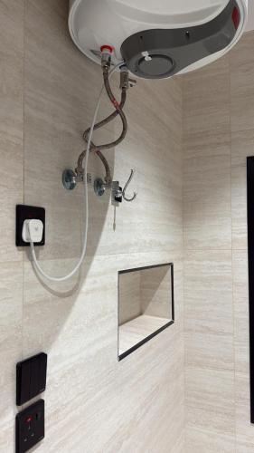 eine Dusche in einem Badezimmer mit einem Spiegel an der Wand in der Unterkunft هاوس تو 21 in Abha