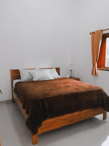 a bedroom with a large wooden bed in a room at Anorawi Surf accommodation in Maluk