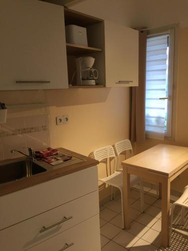 a kitchen with a sink and a table and chairs at Résidence Thibaud in Toulouse