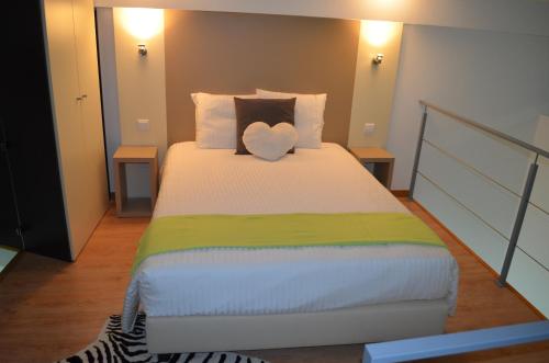 a bedroom with a bed with a heart pillow on it at Apart FL in Mirandela