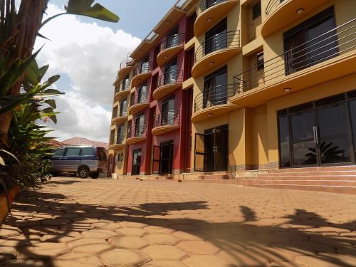 a building with a van parked in front of it at Olina Hotel and Apartments Kampala in Kampala