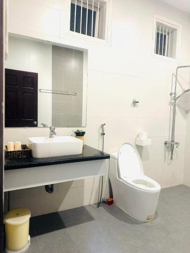a white bathroom with a sink and a toilet at LaLa Villa Đà Lạt in Da Lat