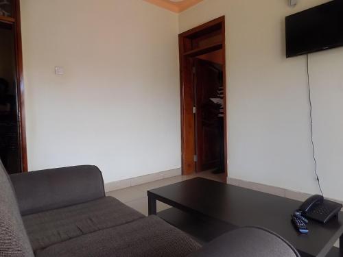 a living room with a couch and a coffee table at Olina Hotel and Apartments Kampala in Kampala