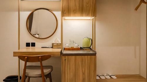 a bathroom with a vanity with a mirror and a stool at Tentram Guest House in Waikabubak