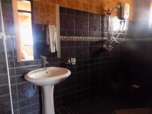 a bathroom with a sink and a mirror at Olina Hotel and Apartments Kampala in Kampala