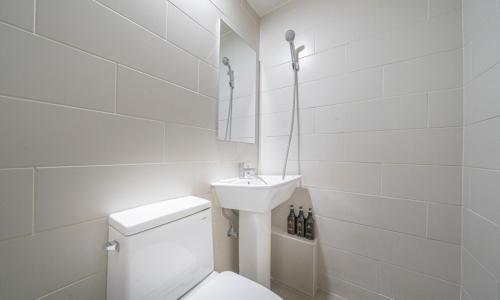a white bathroom with a toilet and a sink at Uiwang Nine Hotel in Uiwang