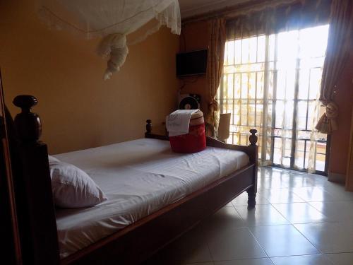 a bedroom with a bed with a red bucket on it at Olina Hotel and Apartments Kampala in Kampala