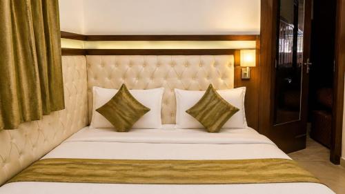 a bedroom with a white bed with two pillows at Hotel Atithi Palace in Sahāranpur